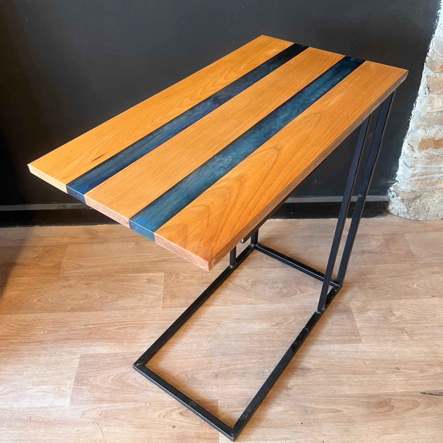 Wooden table with black metal legs on a wooden floor.
