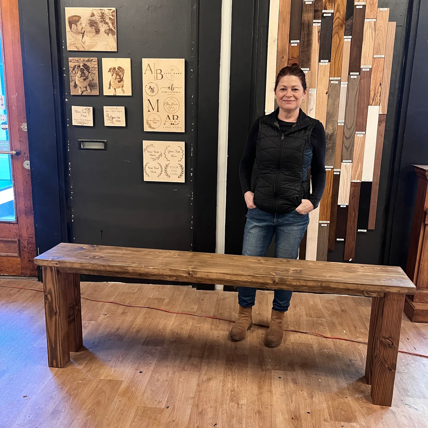Person standing by a wooden sofa table with a decorative wall behind them