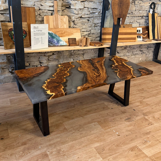 Wood and epoxy coffee table with black metal legs on a wooden floor.