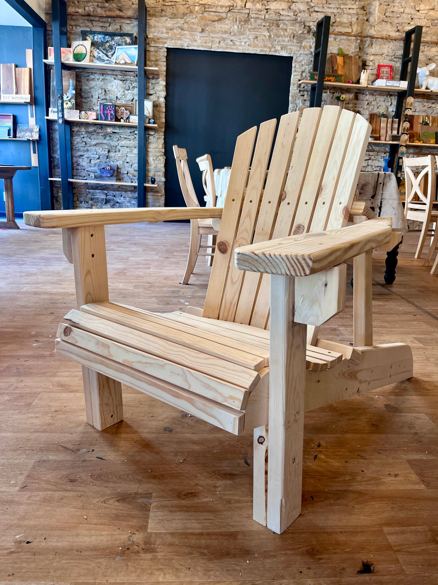 Wooden Adirondack chair in a workshop setting.