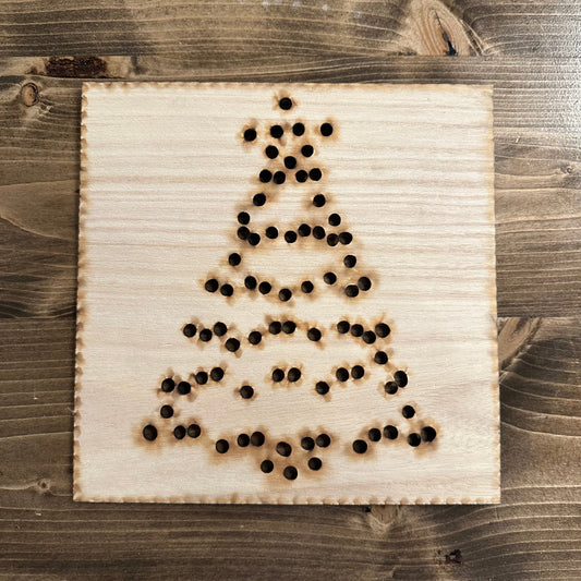 Wooden Christmas tree string art template on a wooden surface