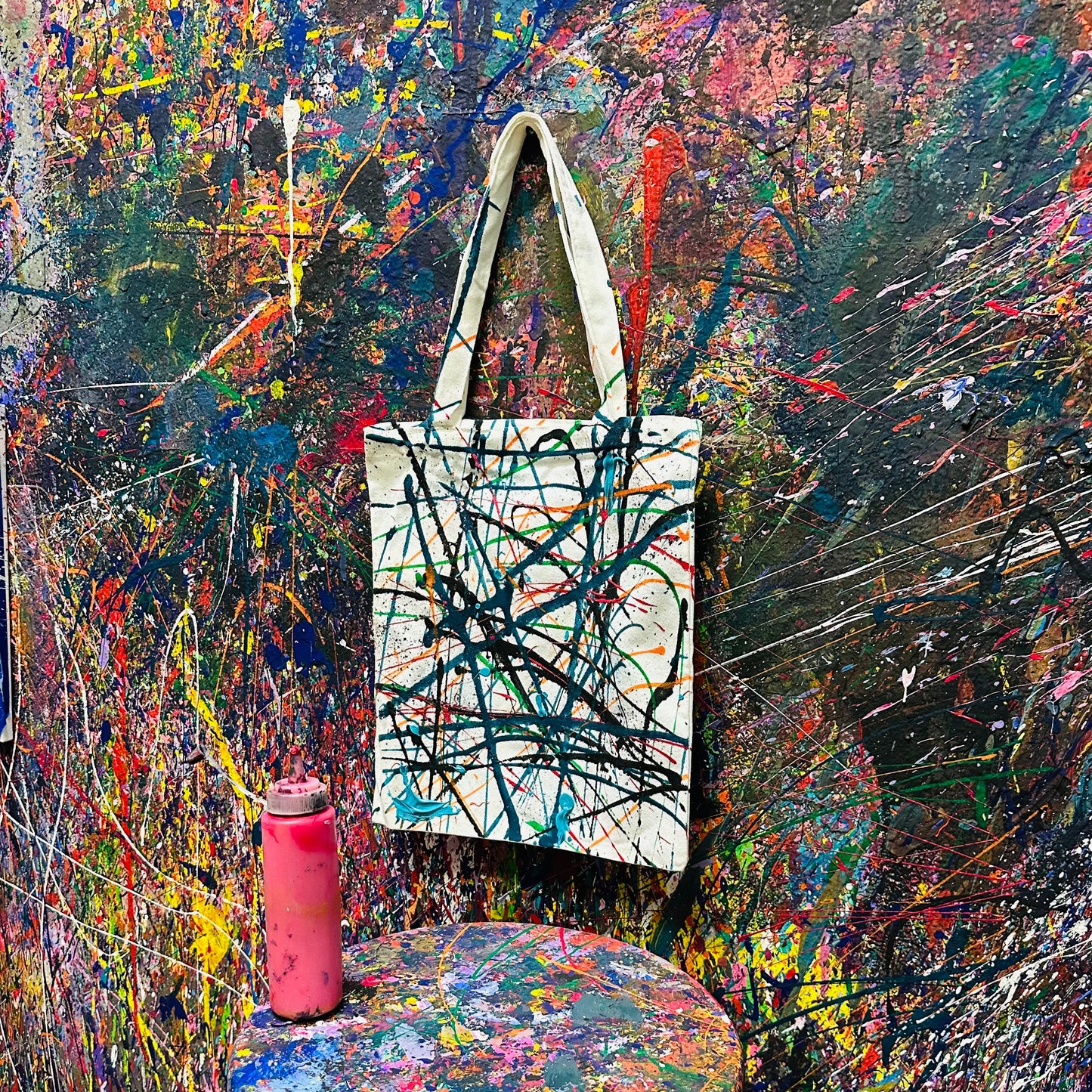 Tote bag with abstract design on a colorful, textured background