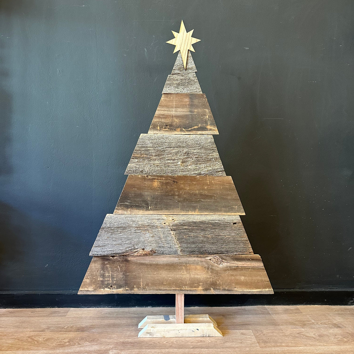 Wooden Christmas tree decoration with a star on a black background