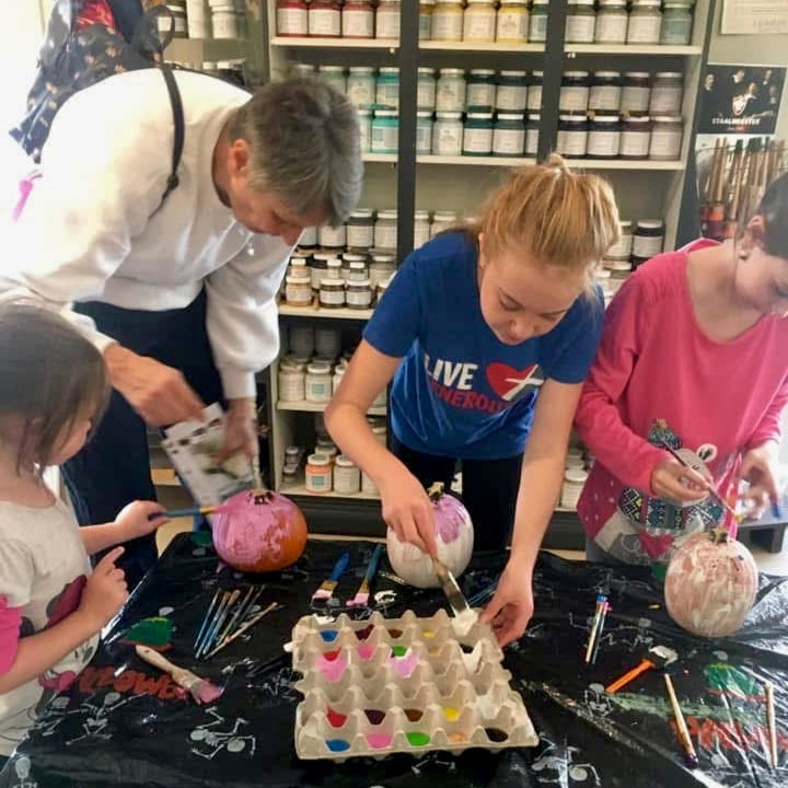 People painting pumpkins at a craft studio