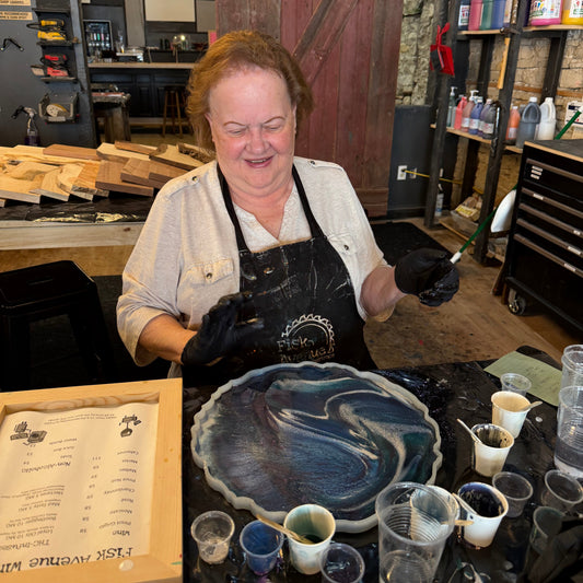 Person sitting in a workshop with an epoxy geode and materials around