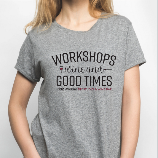 Person wearing a gray t-shirt with text about workshops, wine, and good times.
