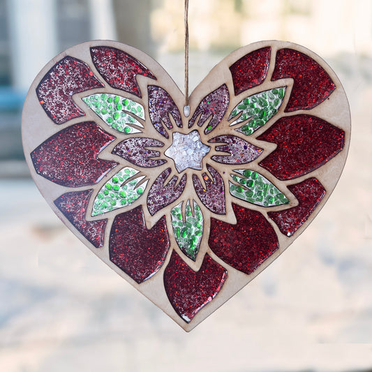Heart-shaped suncatcher with a floral design and glittery finish, hanging against a blurred street scene.