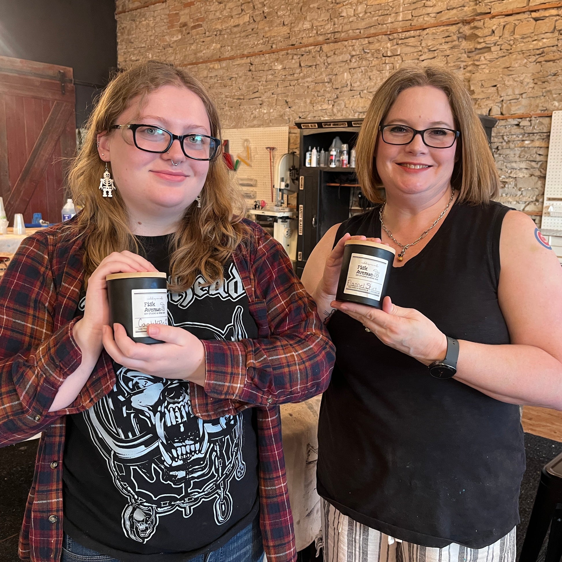 Two women holding candles in a casual indoor setting