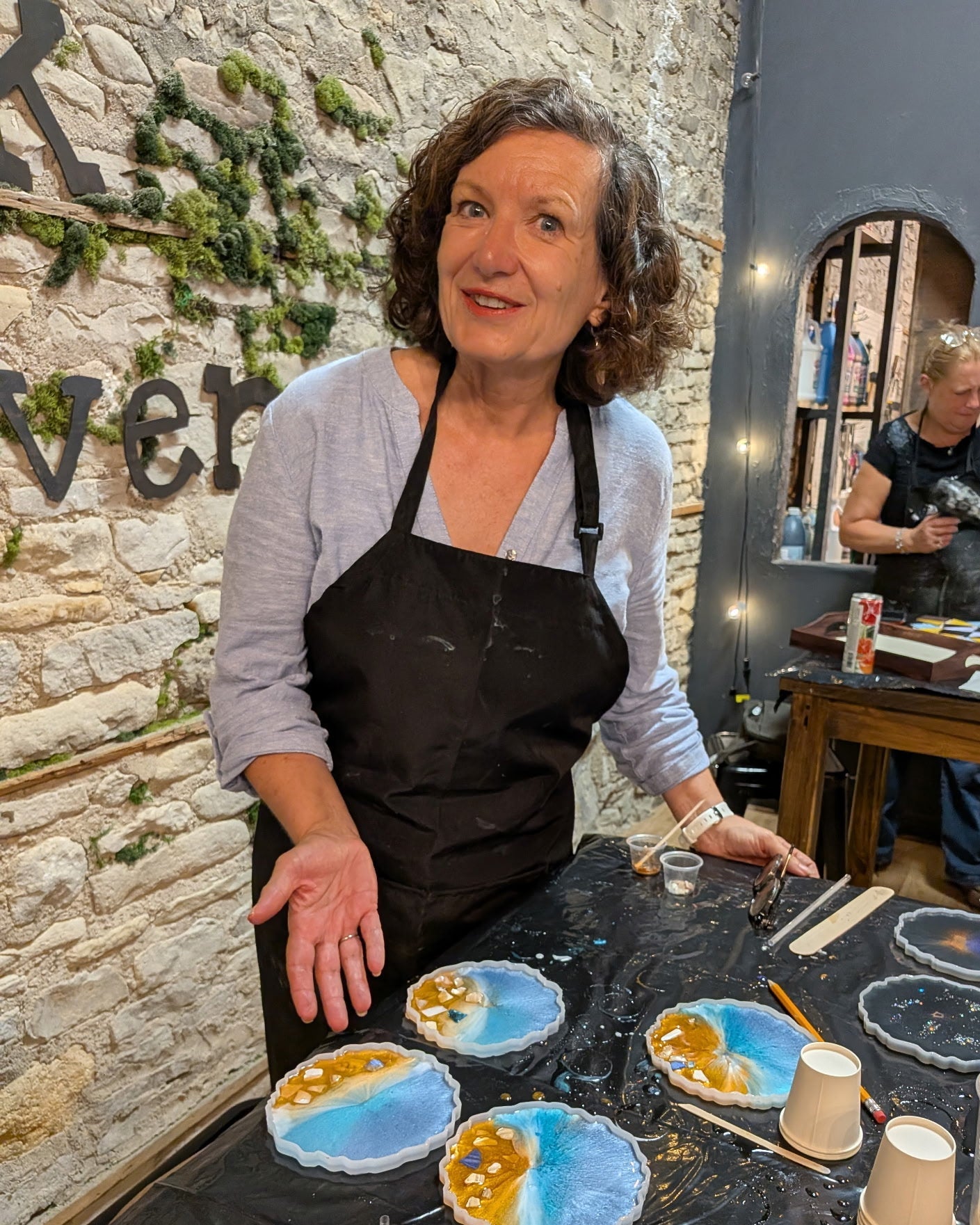 Woman in a studio with epoxy coasters on a table