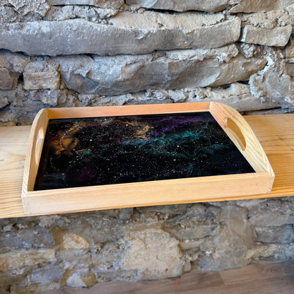 Wooden tray with an epoxy starry night design on a stone wall background