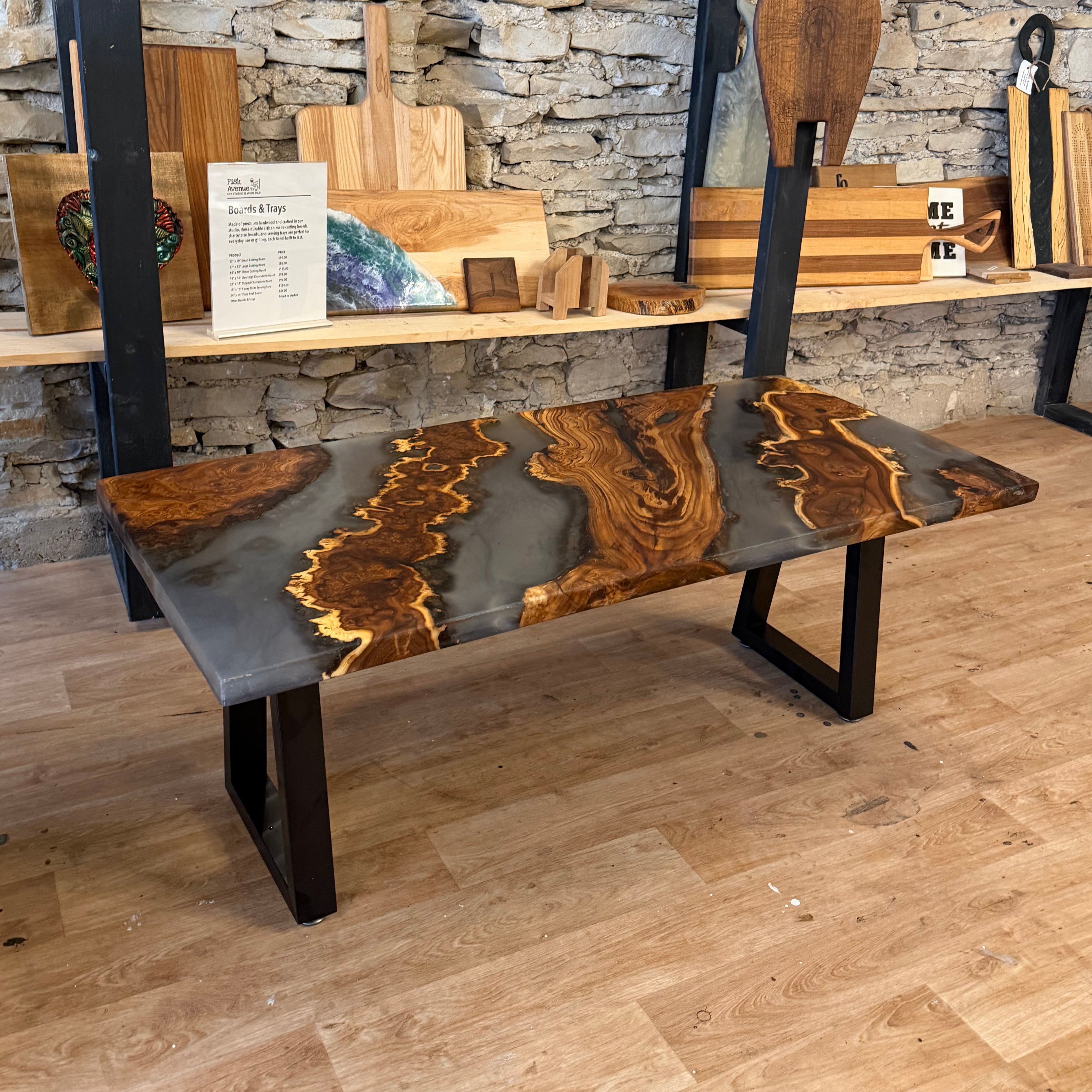 Wood and epoxy coffee table with black metal legs on a wooden floor.