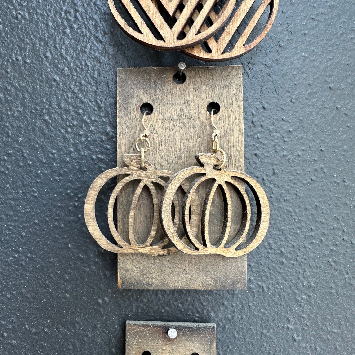 Set of pumpkin earrings displayed on a gray surface