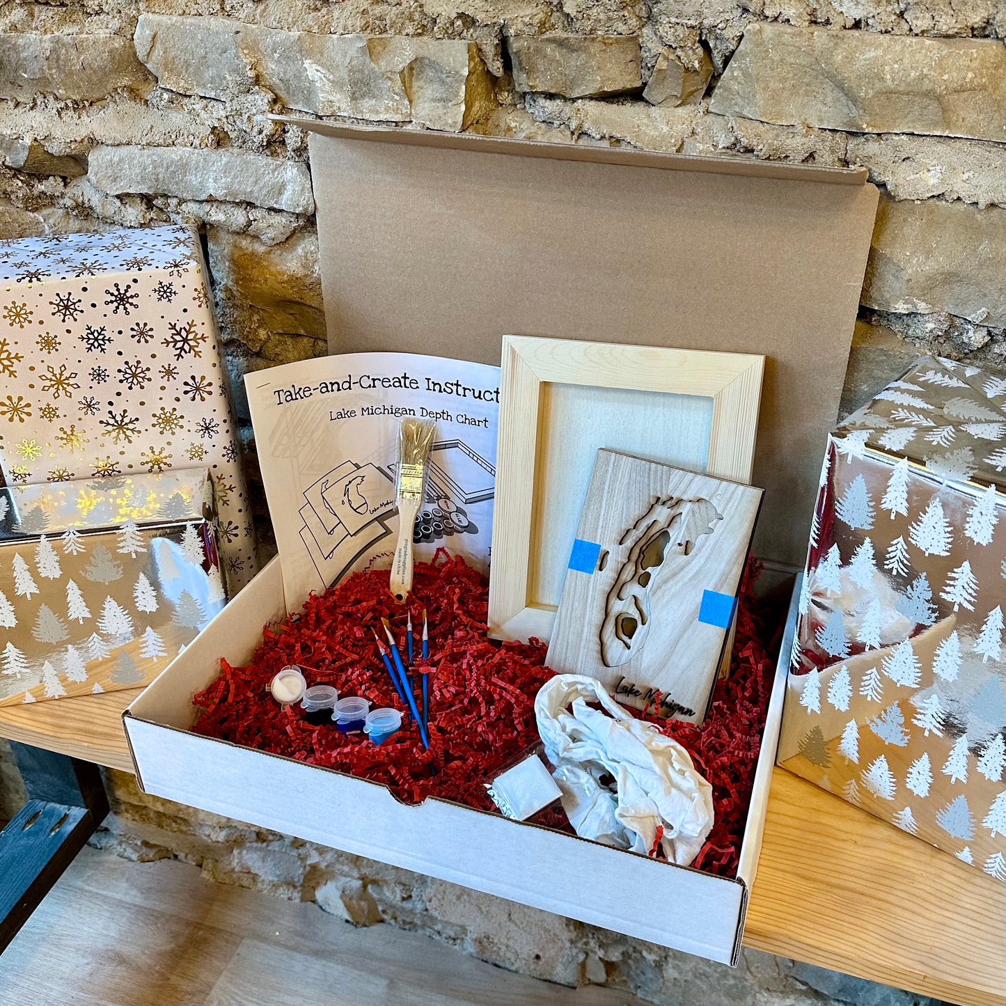 Box containing wooden art supplies and instructions against a stone wall background