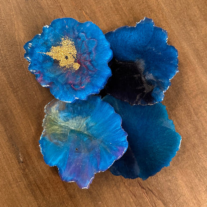 Blue epoxy coasters with gold center on a wooden surface
