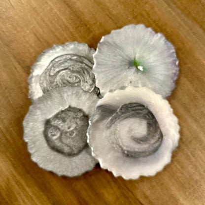 Three silver epoxy coasters on a wooden surface