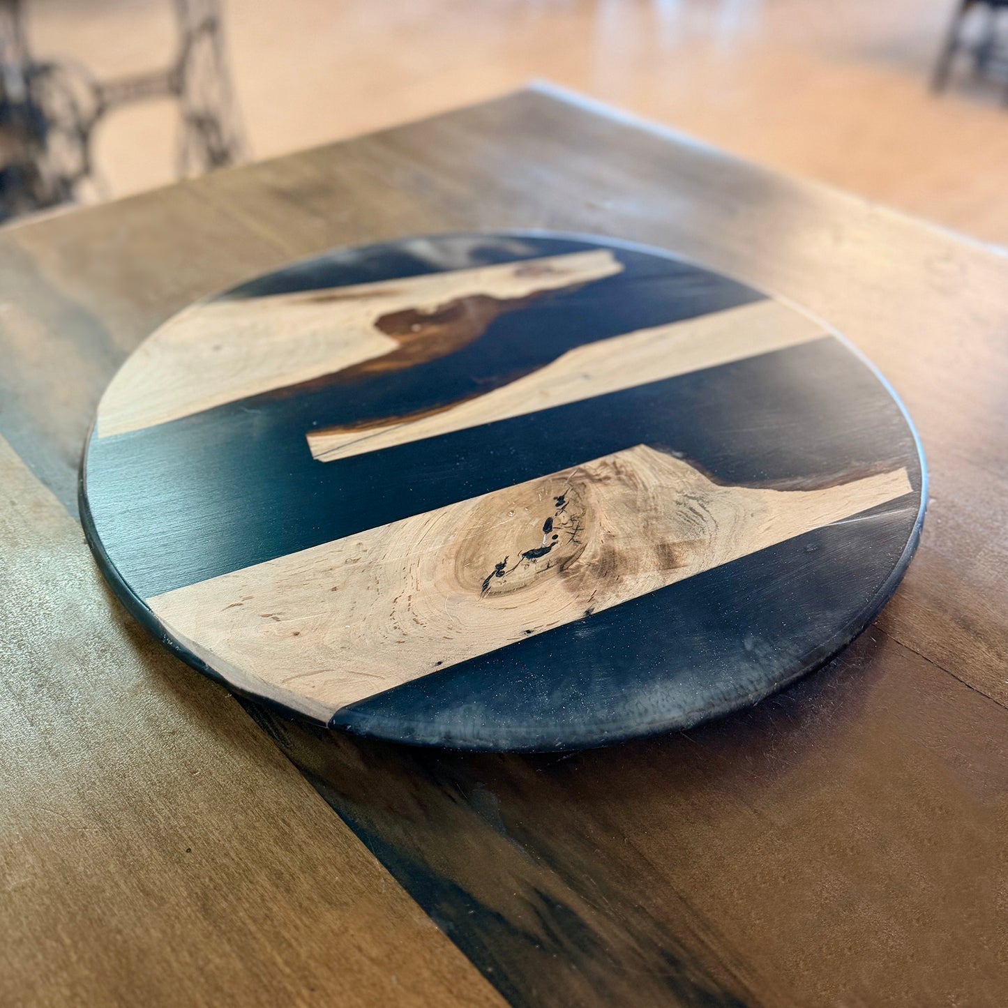 Round wood and epoxy Lazy Susan with natural wood grain patterns on a table