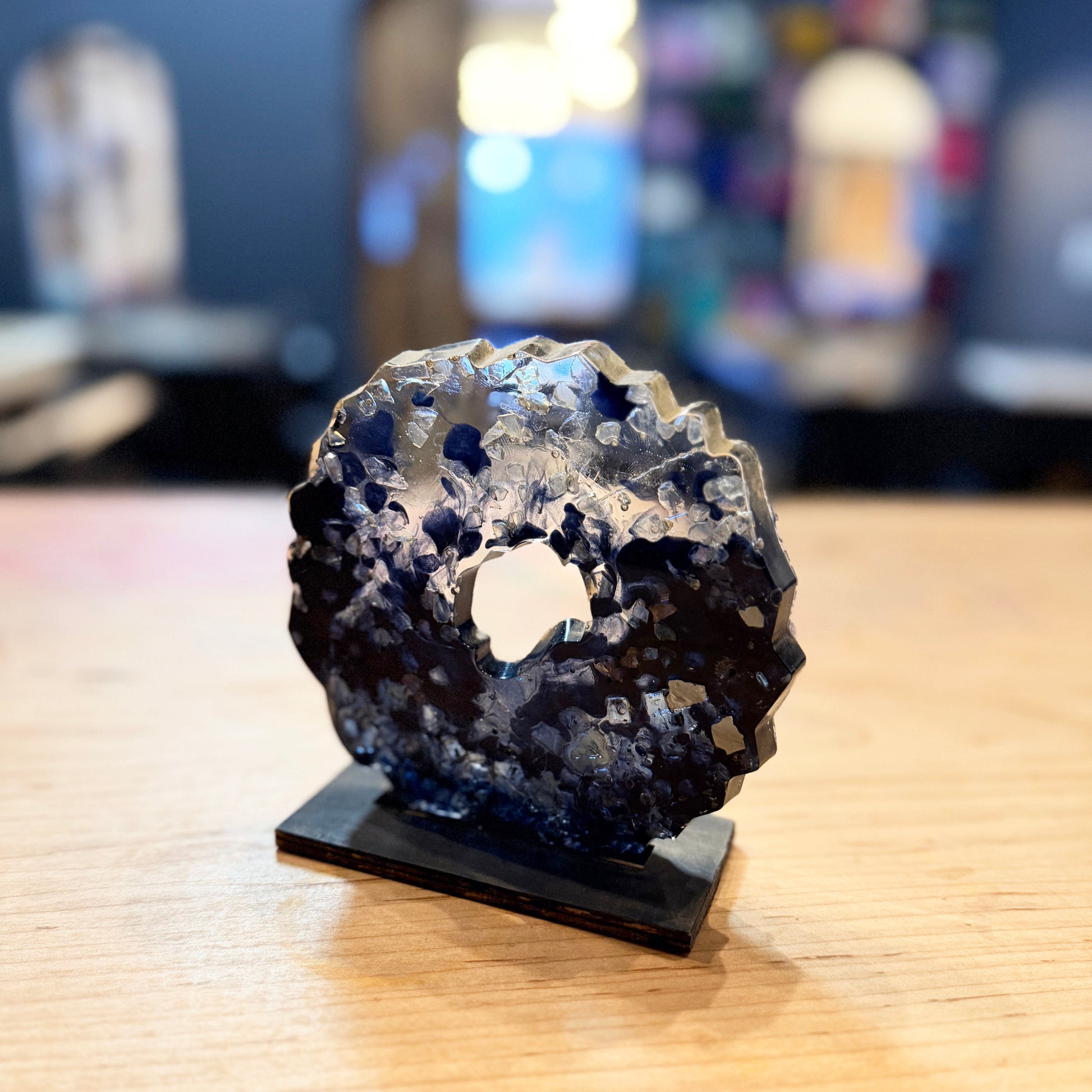 Epoxy geode with glass crystals on a stand with a blurred background