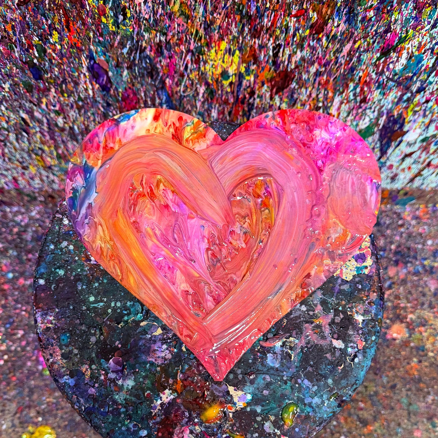 Colorful heart-shaped wooden cutout on a painted textured surface