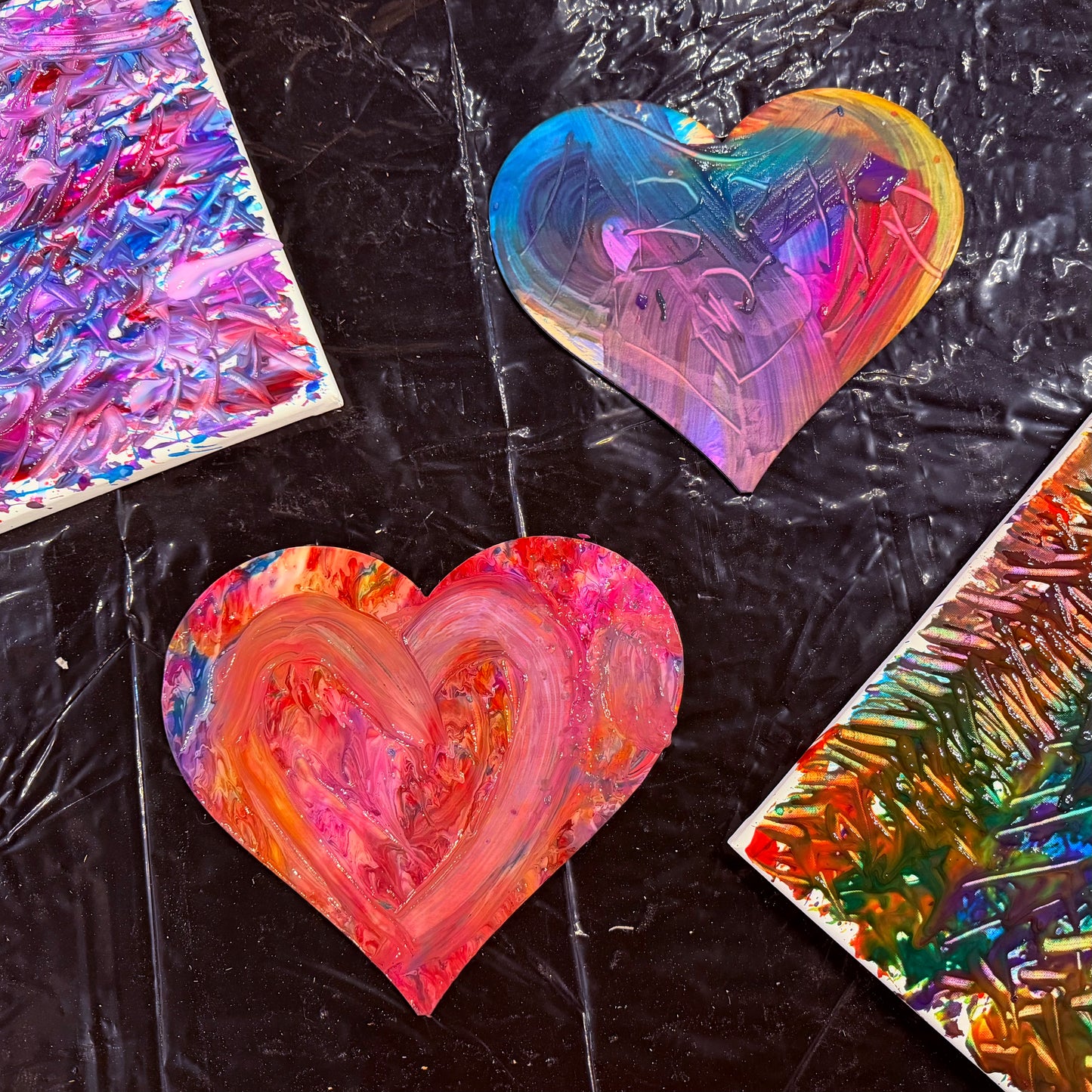 Colorful heart-shaped art pieces on a black textured background