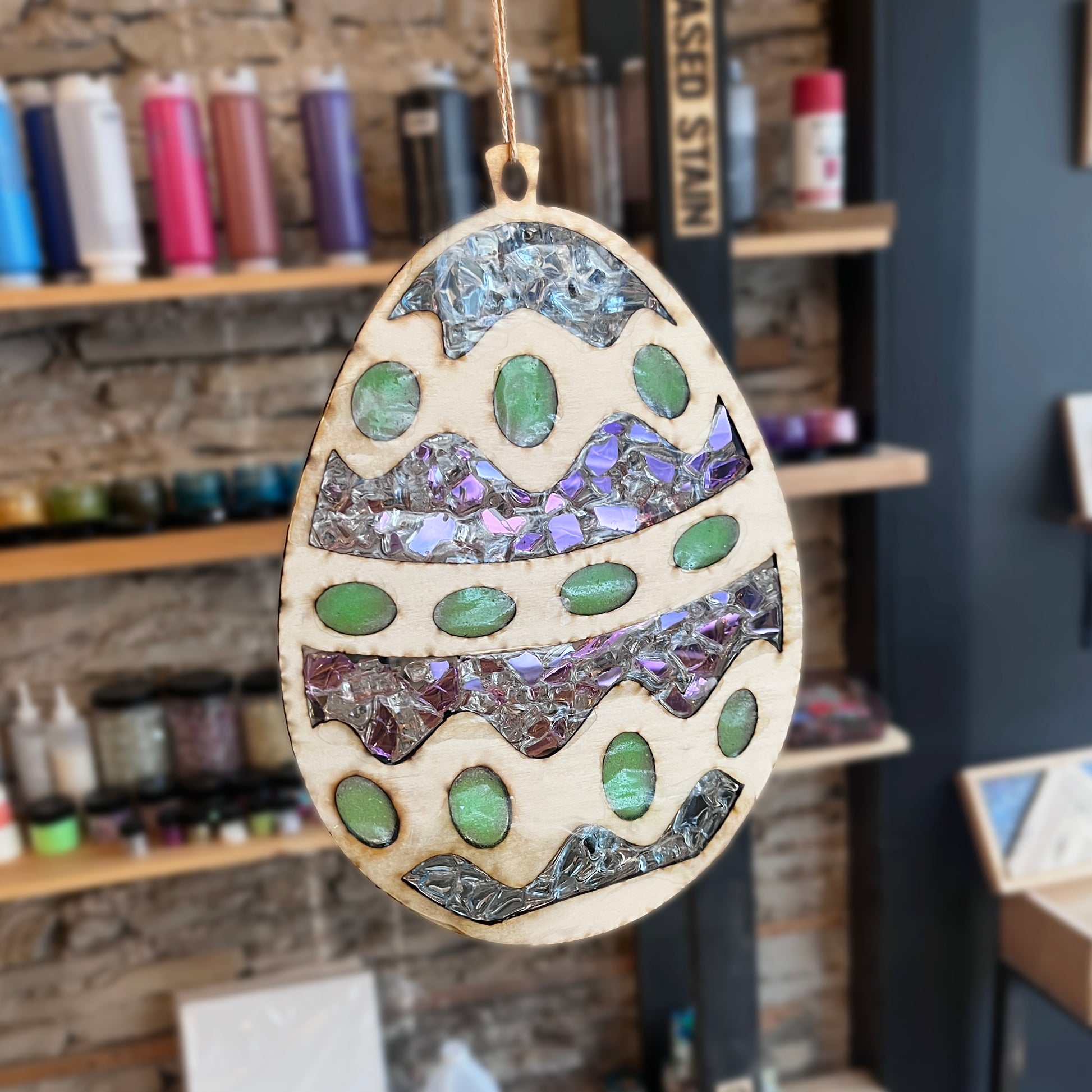 Decorative wooden egg suncatcher with mosaic design in a studio setting