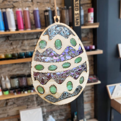 Decorative wooden egg suncatcher with mosaic design in a studio setting