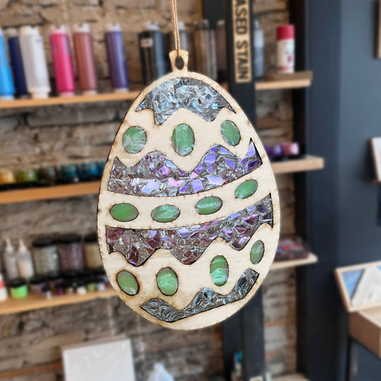 Decorative wooden egg suncatcher with mosaic design in a studio setting