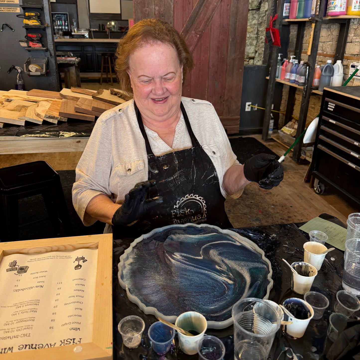 Person sitting in a workshop with an epoxy geode and materials around