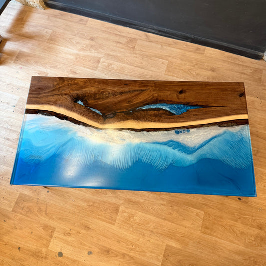 Wooden table with blue shore resin design on a wooden floor