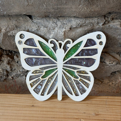 Wood butterfly suncatcher on a stone and wooden surface