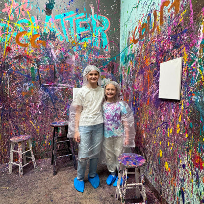 Two people in a room with colorful graffiti on the walls.