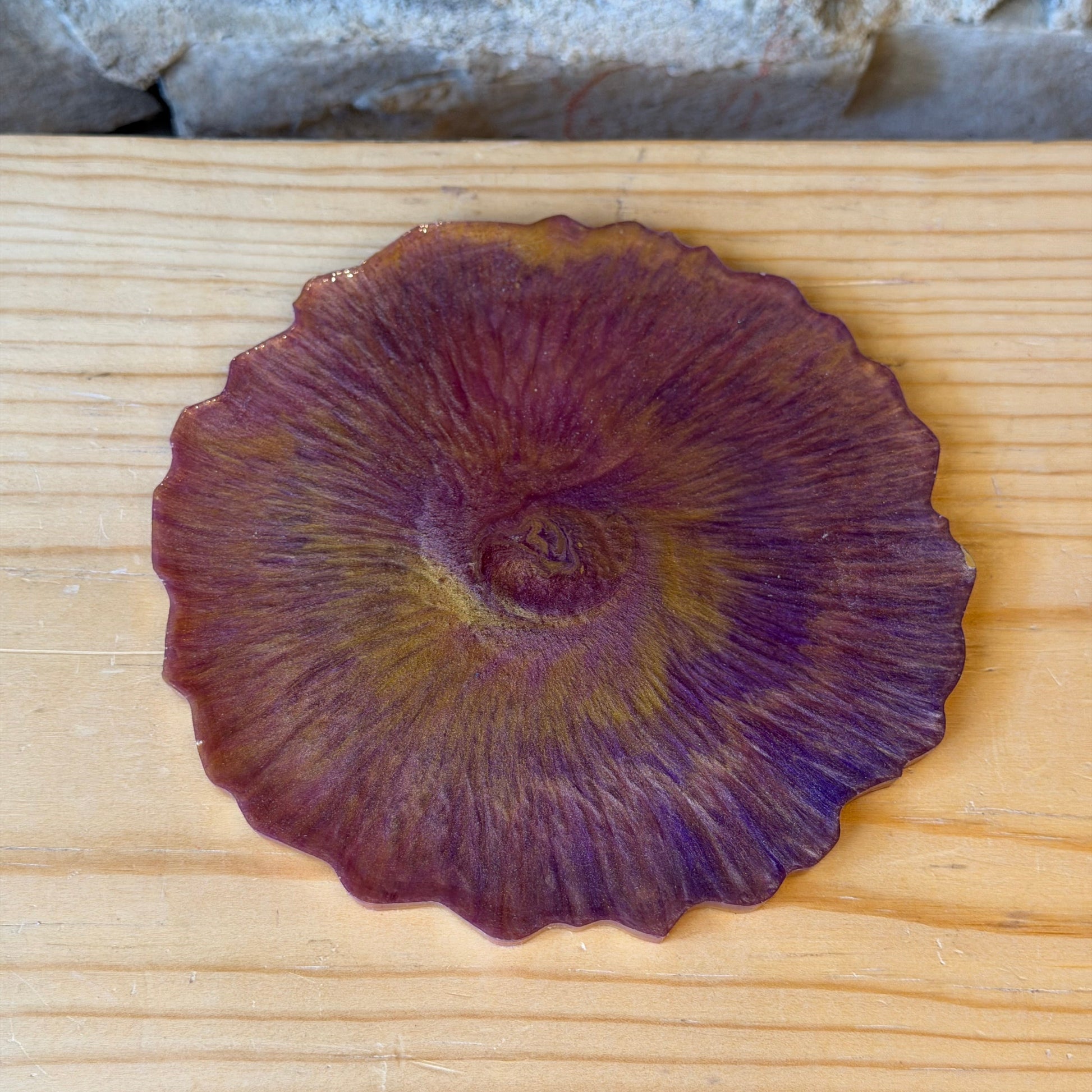 Decorative purple epoxy coaster on a wooden surface