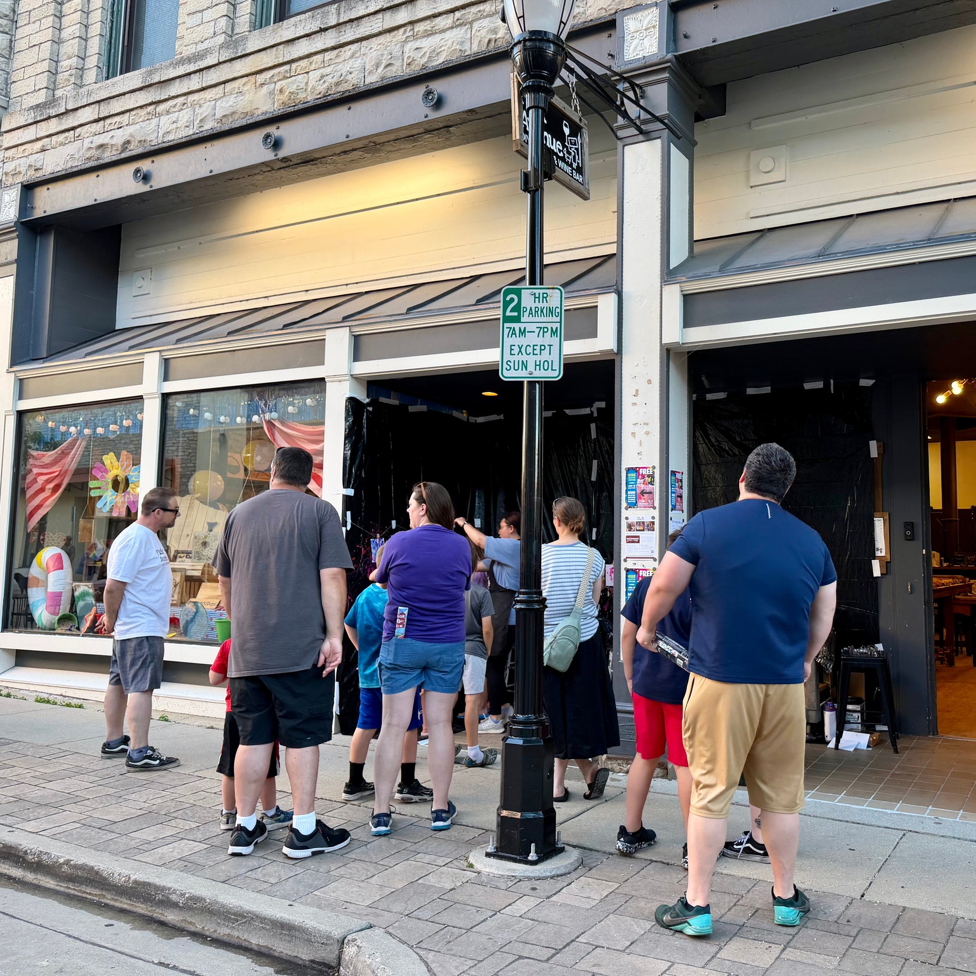 People standing outside a studio on a city street