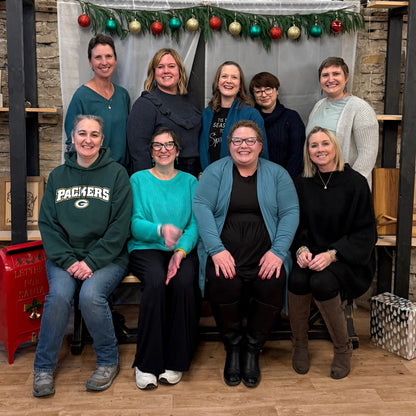 Group of women posing together in a festive setting with Christmas decorations.