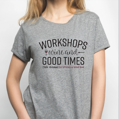 Person wearing a gray t-shirt with text about workshops, wine, and good times.