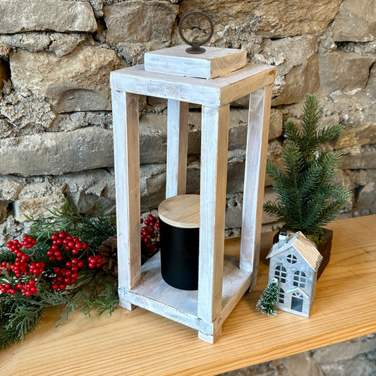 Wooden lantern with decorative holiday items on a stone wall background