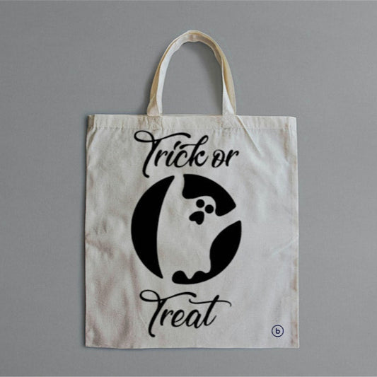 A white tote bag with 'Trick or Treat' text and a graphic of a ghost stenciled on the front.