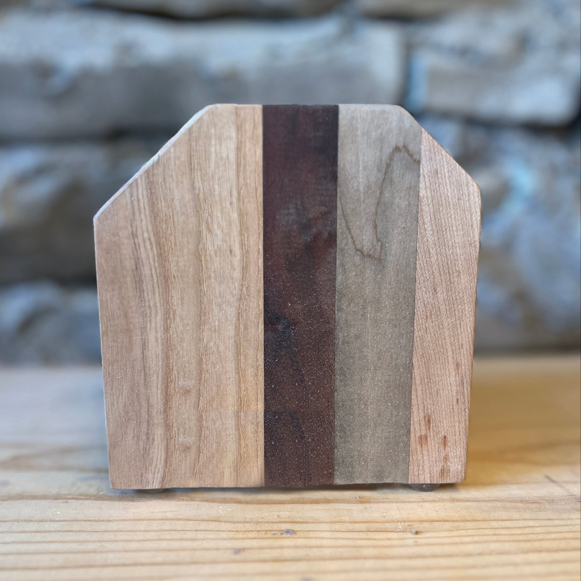 Striped wooden napkin holder with a stone background.